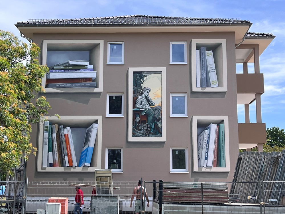 31.05.2023 Das Fassadenbild am Giebel ist fertig gestellt - Heinrich Heine umgeben von Bücherregalen
